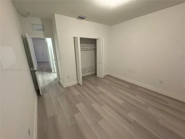a view of empty room with wooden floor