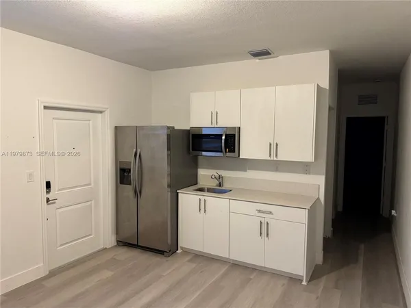 a kitchen with stainless steel appliances a refrigerator sink and cabinets