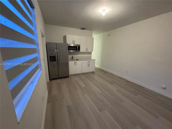 a kitchen with cabinets and wooden floor