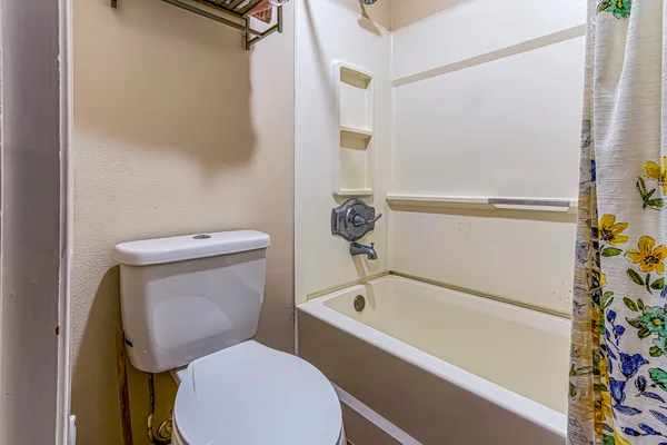 a white toilet sitting next to a bath tub