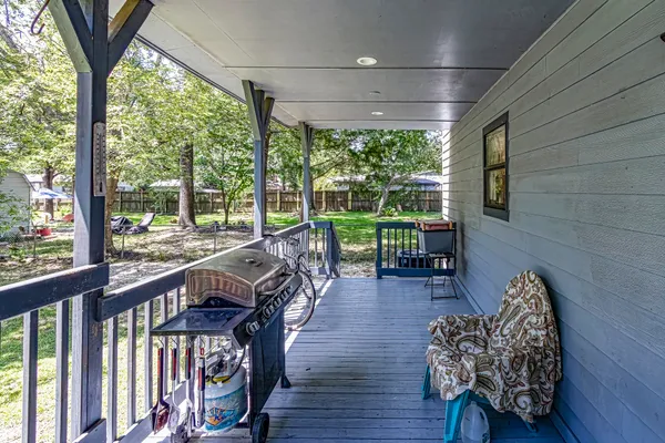 a view of a porch with furniture and wooden floor