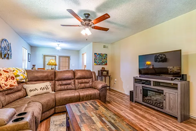 a living room with furniture a flat screen tv and a fireplace