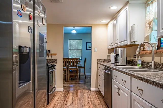 a kitchen with stainless steel appliances granite countertop a refrigerator and a sink