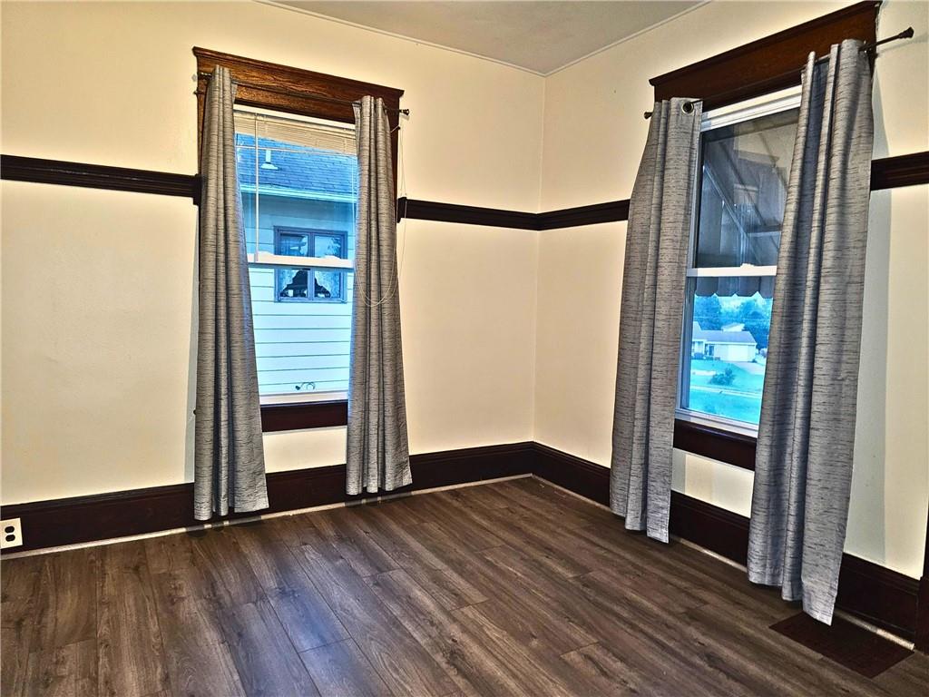 1056 Adams Street New Castle, PA 16101 - Photo 13 of 21 an empty room with wooden floor mirror and windows