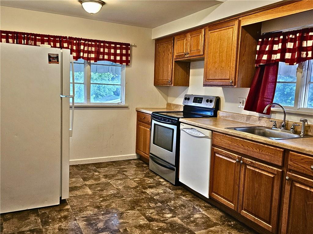 1056 Adams Street New Castle, PA 16101 - Photo 14 of 21 a kitchen with a stove a sink and a refrigerator