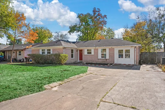 a front view of a house with a garden and trees
