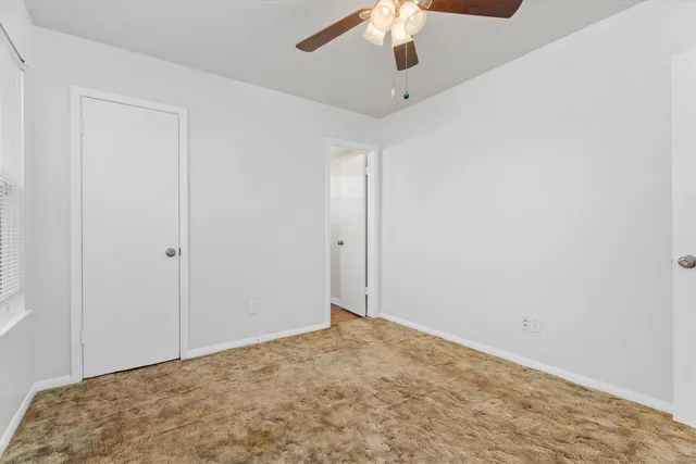 an empty room with a chandelier fan
