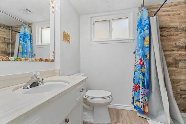 a bathroom with a sink a toilet and a shower curtain