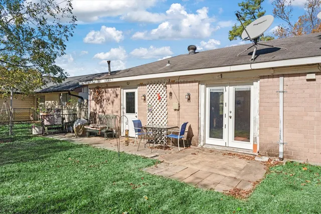 a view of a patio with table and chairs and floor to ceiling window