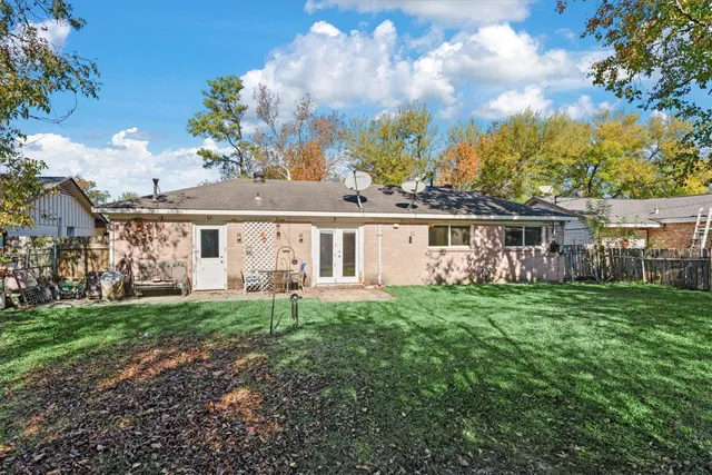 a view of a house with a big yard and large trees