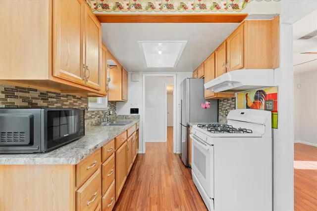 a kitchen with stainless steel appliances granite countertop a stove and a refrigerator