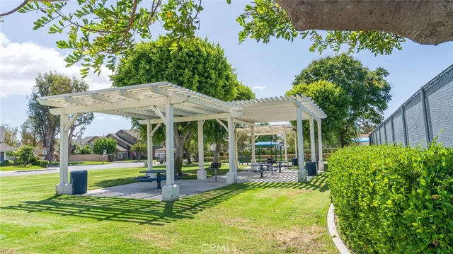 a view of a patio with table and chairs potted plants and a large tree