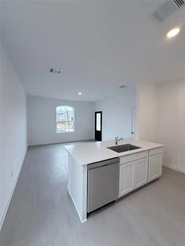 a view of a kitchen with two sinks a refrigerator and a stove