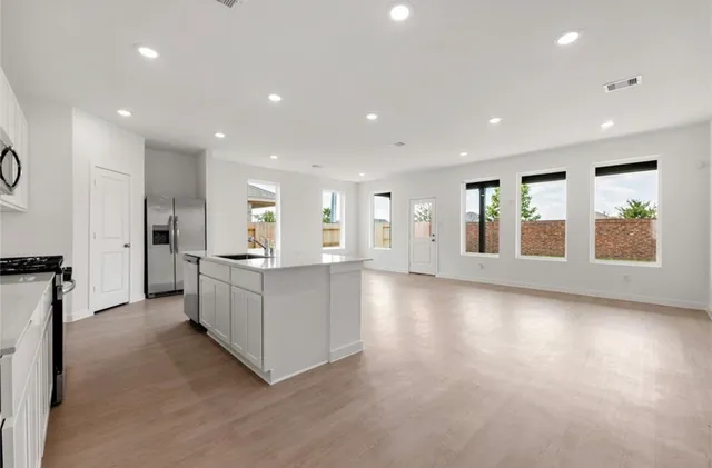 a view of a kitchen with refrigerator and windows