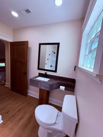 a bathroom with a toilet sink and mirror