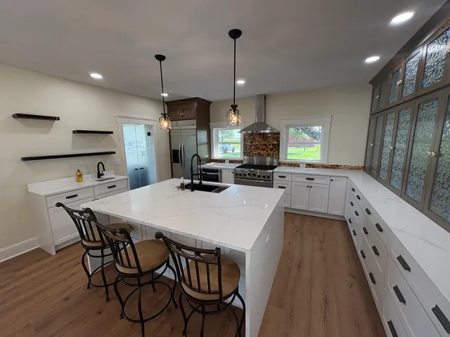 a kitchen with kitchen island a wooden floor and white appliances