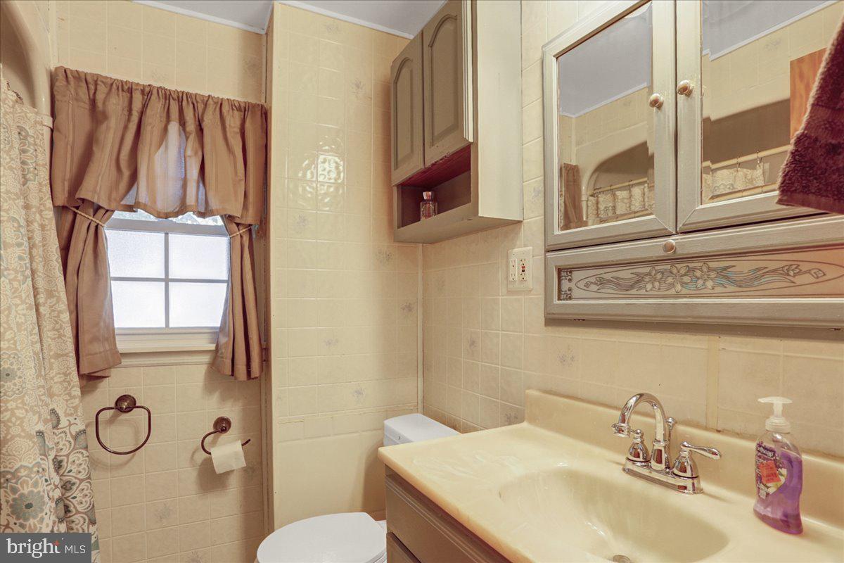 32 2nd Street Shillington, PA 19607 - Photo 18 of 26 a bathroom with a granite countertop toilet sink and mirror