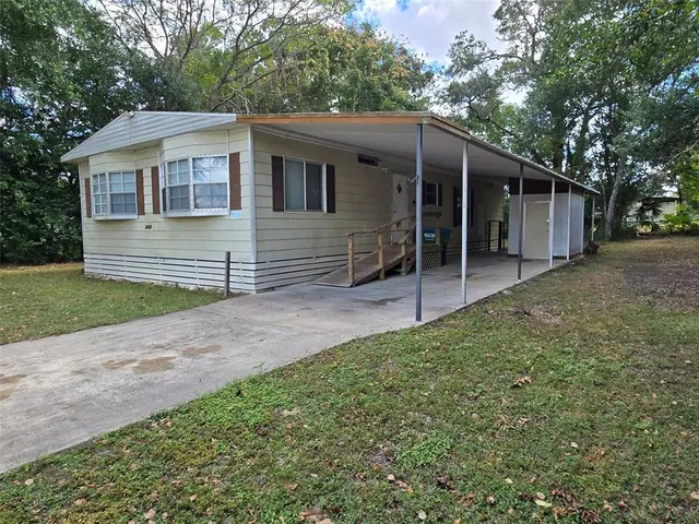 a view of a house with a yard and large tree