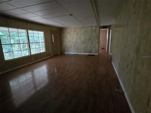 a view of a room has wooden floor and windows