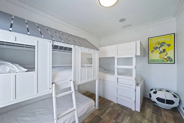 a large bedroom with a bed and wooden floor