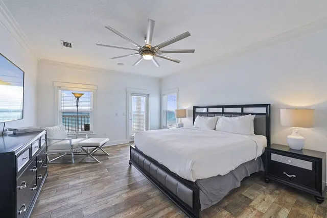 a spacious bedroom with a large bed and a chandelier