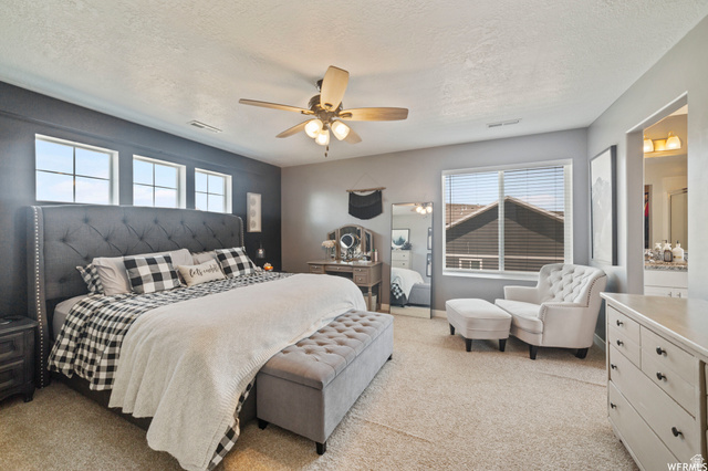1836 Red Oak Road Eagle Mountain, UT 84005 - Photo 4 of 15 Bedroom with light carpet, a ceiling fan, a textured ceiling, and connected bathroom