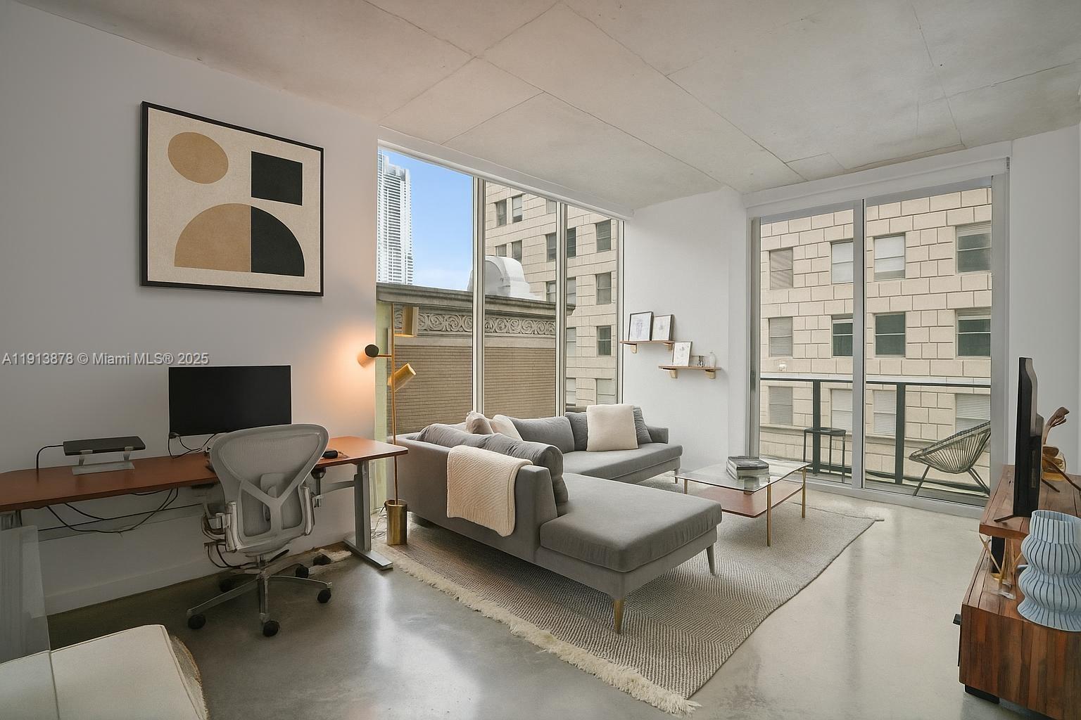 151 Southeast 1st Street, Unit 502 Miami, FL 33131 - Photo 1 of 21 a view of a livingroom with workspace and a couch