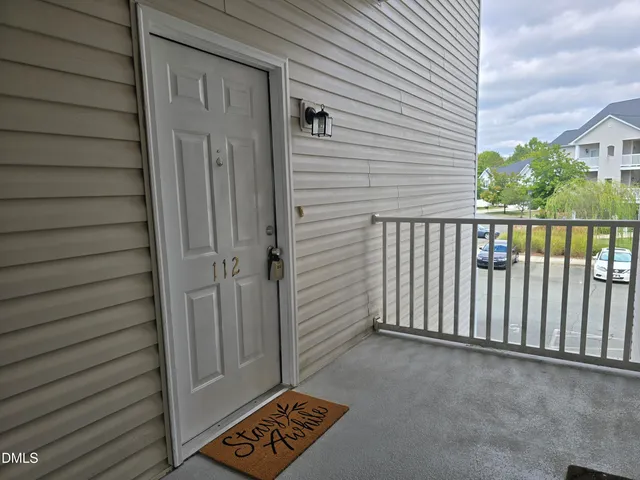 a view of a porch with a door and wooden floor