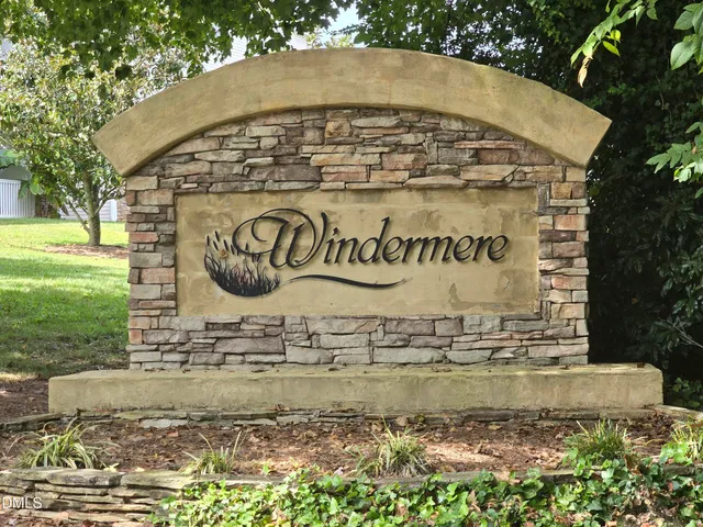 a view of a sign under a large trees