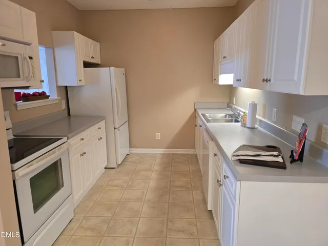 a kitchen with stainless steel appliances a stove a sink a refrigerator and cabinets