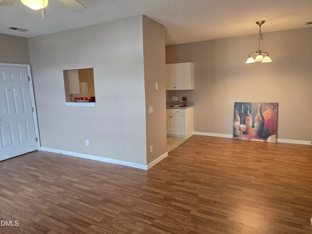 a view of empty room with wooden floor