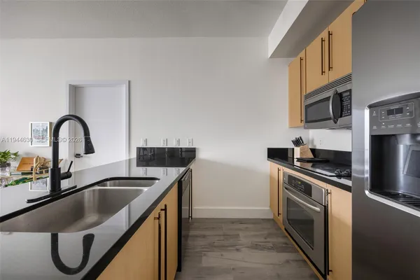 a kitchen with stainless steel appliances granite countertop a sink stove and refrigerator