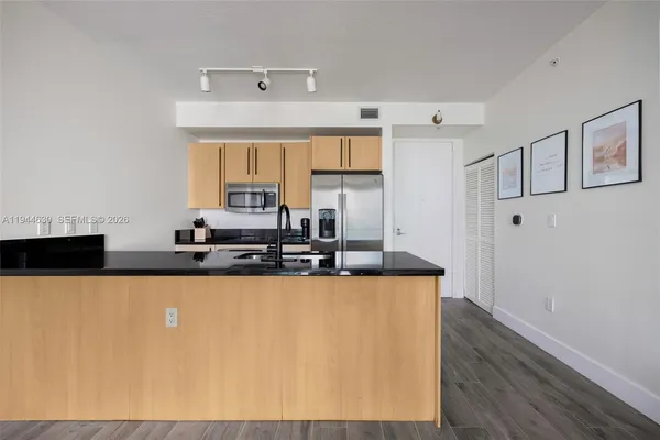 a kitchen with stainless steel appliances a sink a stove a microwave a counter top and cabinets