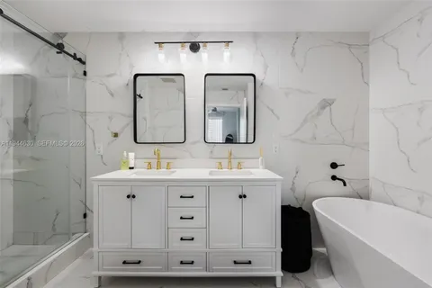 a bathroom with a double vanity sink mirror and bathtub