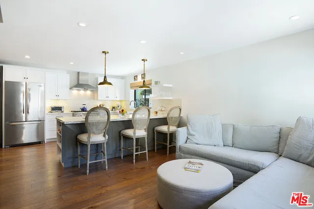 a kitchen with a dining table chairs and refrigerator