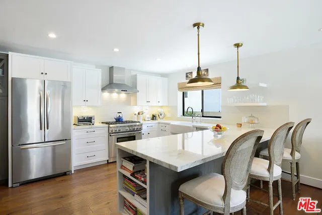 a kitchen with white cabinets appliances and a window