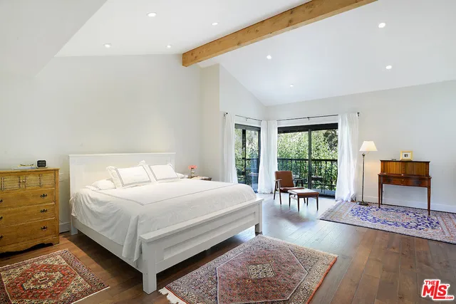 a balcony with wooden floor potted plants and outdoor seating
