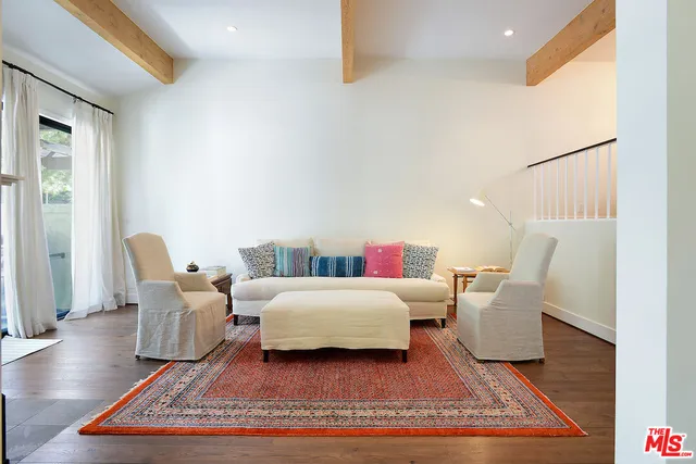 a living room with furniture rug and wooden floor