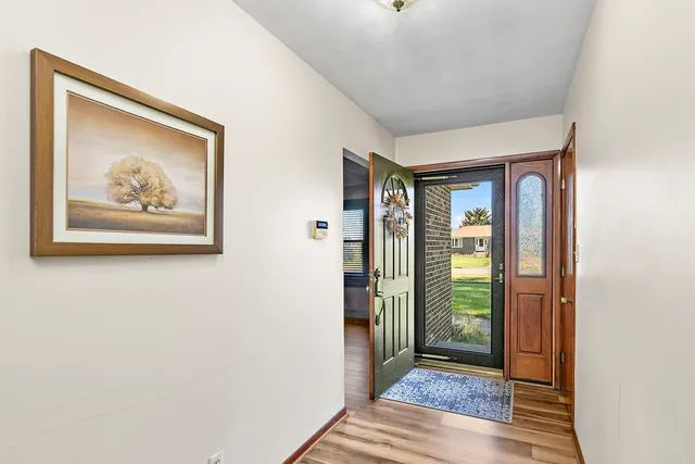 a view of a hallway with wooden floor and closet