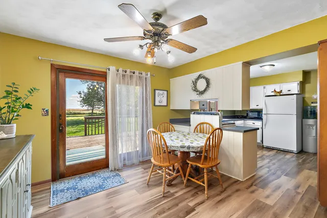 a kitchen with granite countertop a white refrigerator oven a sink dishwasher and white cabinets with wooden floor