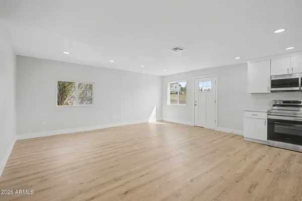 a view of a kitchen with a sink and dishwasher a refrigerator with wooden floor