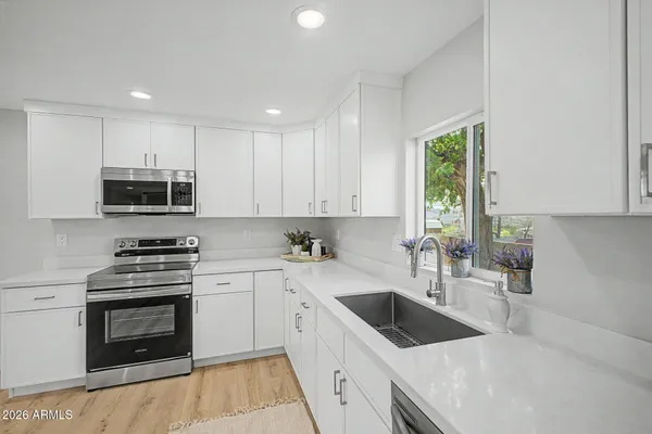 a kitchen with stainless steel appliances granite countertop a refrigerator sink and cabinets