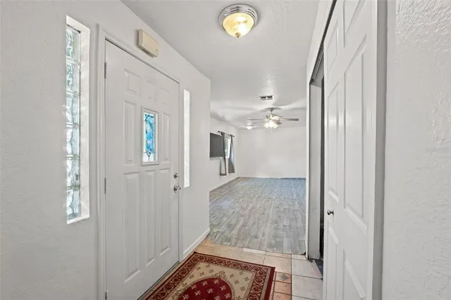 a view of a big room with wooden floor and a ceiling fan