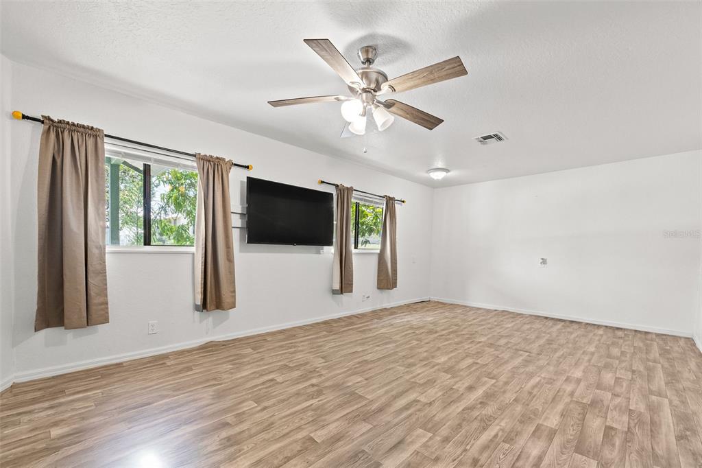304 Shepard Avenue Dundee, FL 33838 - Photo 21 of 62 a view of an empty room with a window and wooden floor
