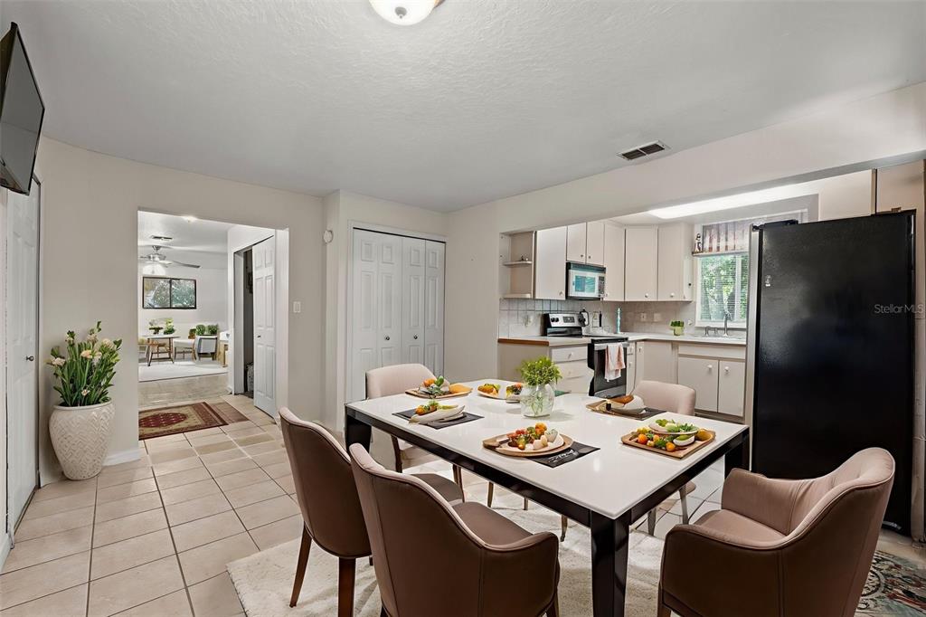 304 Shepard Avenue Dundee, FL 33838 - Photo 32 of 62 a kitchen with a table chairs and a refrigerator