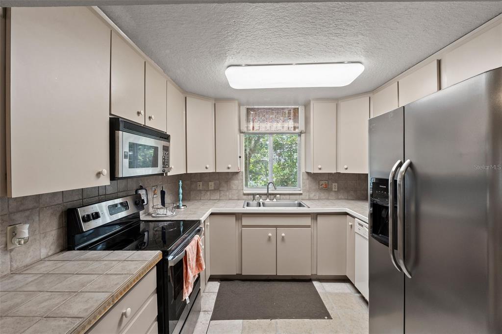 304 Shepard Avenue Dundee, FL 33838 - Photo 33 of 62 a kitchen with a sink stove and refrigerator