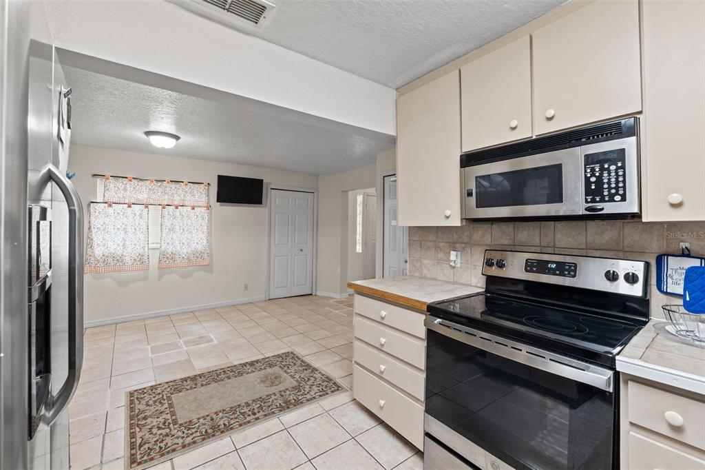 304 Shepard Avenue Dundee, FL 33838 - Photo 35 of 62 a kitchen with granite countertop a stove and a microwave