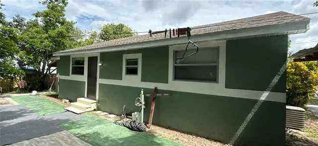 a backyard of a house with table and chairs plants and trees