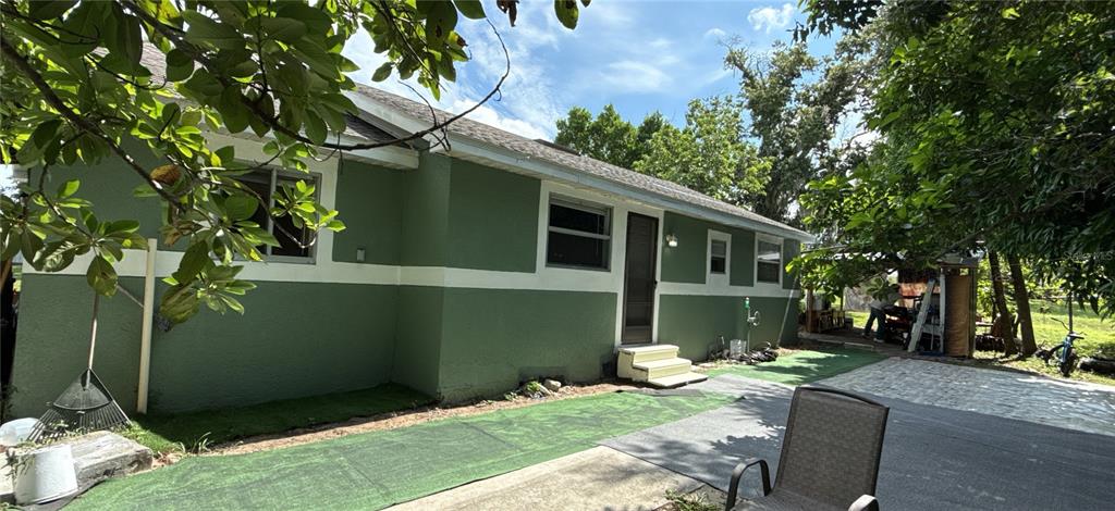 304 Shepard Avenue Dundee, FL 33838 - Photo 6 of 62 a backyard of a house with table and chairs plants and trees