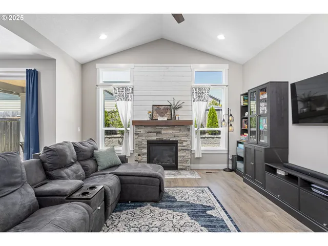 a living room with furniture a flat screen tv and a fireplace